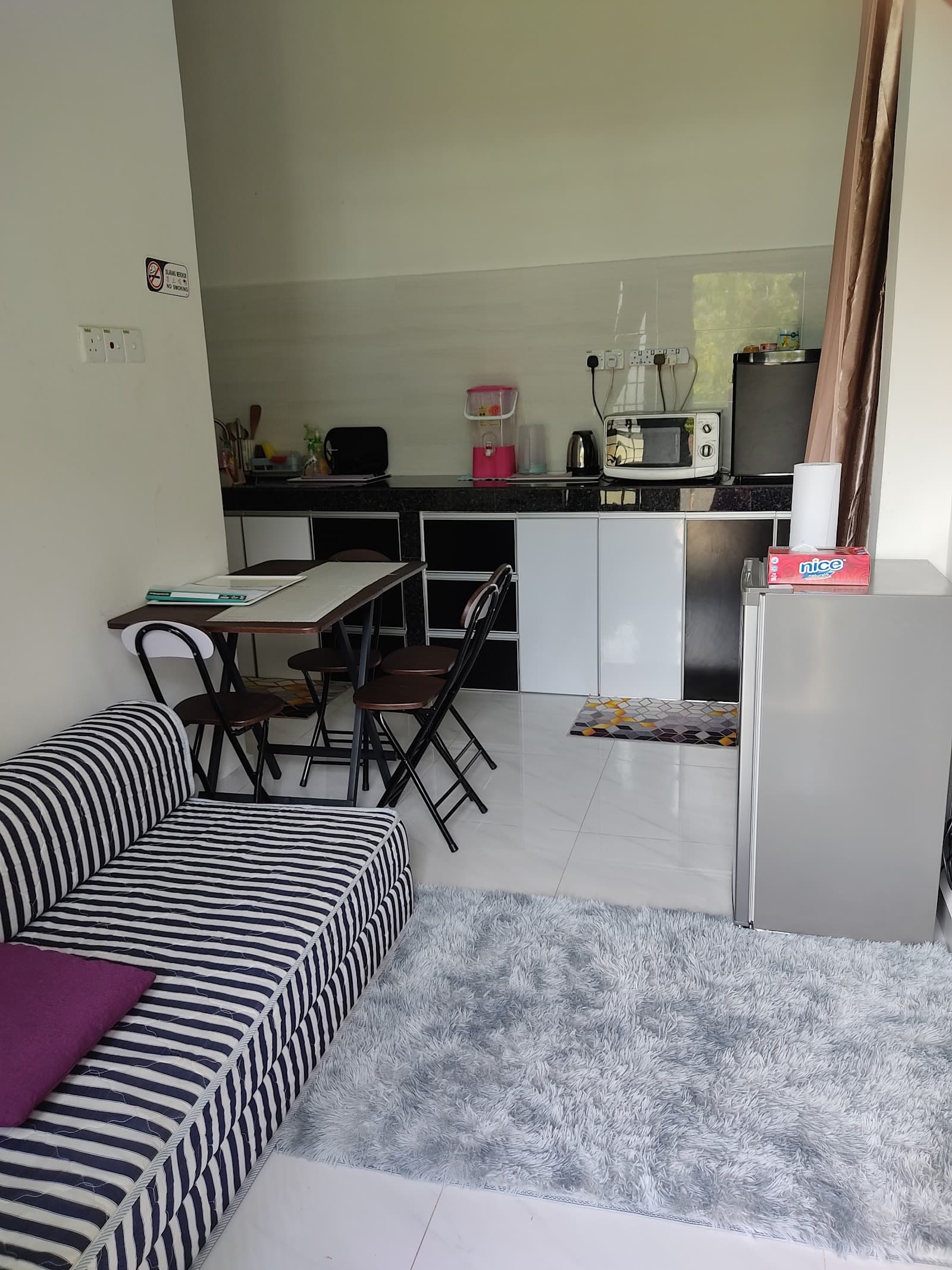 Dapur dengan peti sejuk dan ketuhar gelombang mikro, serta meja makan